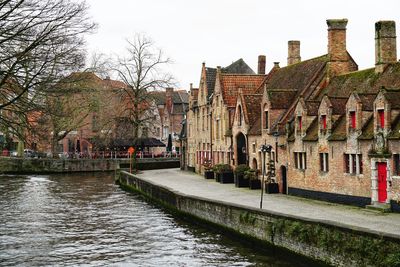 Canal amidst buildings in town against sky