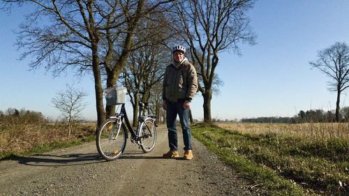 Man riding bicycle on road against sky