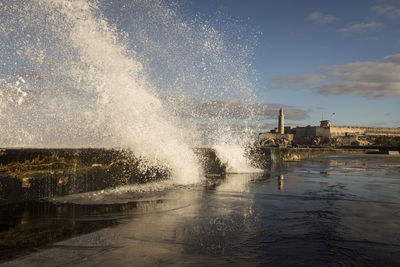 Water splashing in sea against sky