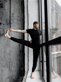 Full length of young man looking through window