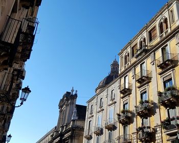 Low angle view of buildings against clear blue sky