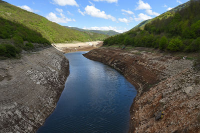 Scenic view of river amidst mountains against sky