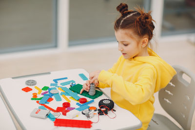 Girl with toys on table