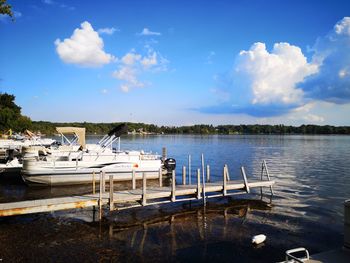 View of boats in lake against cloudy sky