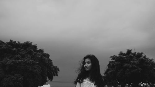 Low angle view of woman standing against sky