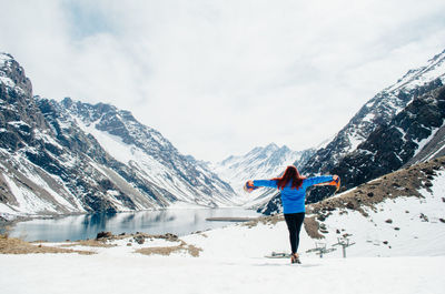 Rear view of person on snowcapped mountains against sky