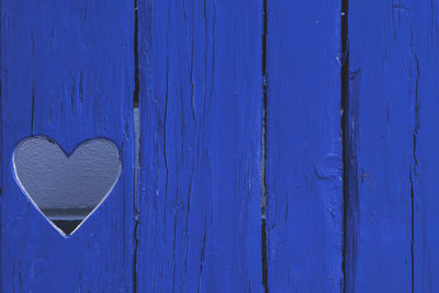 Close-up of heart shape on blue door