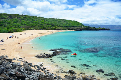 A picture perfect summer day at waimea bay with relaxing calm clear turquoise water on oahu, hawaii.