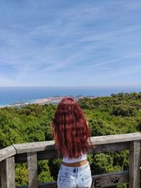 Rear view of man looking at sea against sky