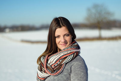 Portrait of young woman in winter against sky