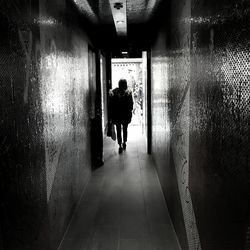 Rear view of man walking in corridor