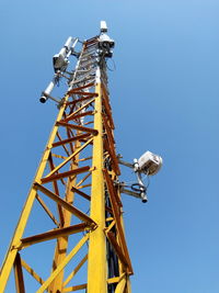 Low angle view of communications tower against clear blue sky