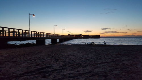 Pier on sea at sunset