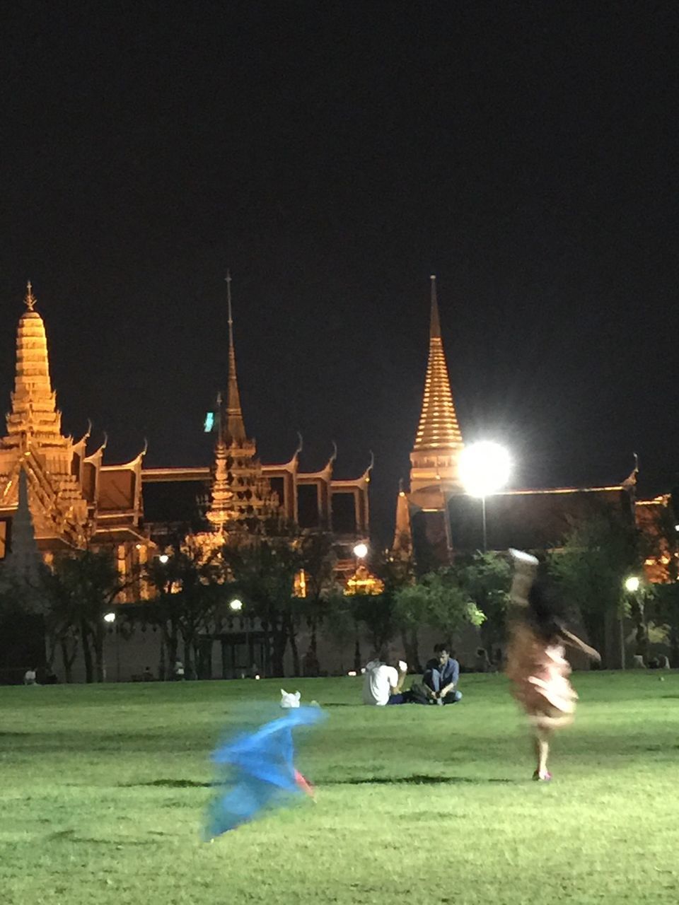 architecture, building exterior, illuminated, night, built structure, place of worship, religion, clear sky, tradition, light, outdoors, pagoda, facade, person