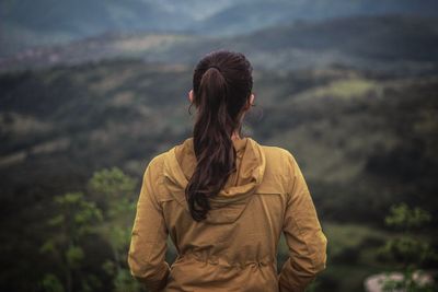 Rear view of woman standing against mountain