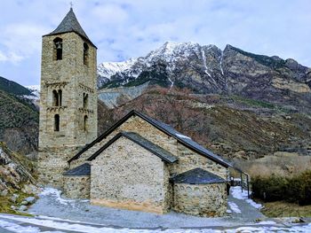 Built structure on snow covered mountain against sky