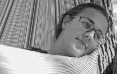 Close-up of thoughtful woman looking away relaxing in hammock