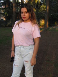 Portrait of beautiful young woman standing on land