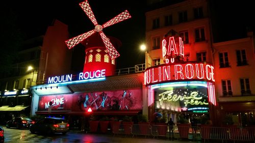 Low angle view of illuminated sign on street at night