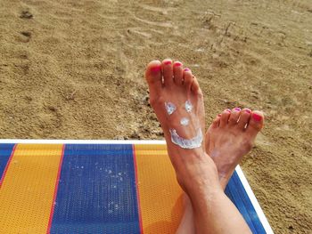 Low section of person relaxing on sand