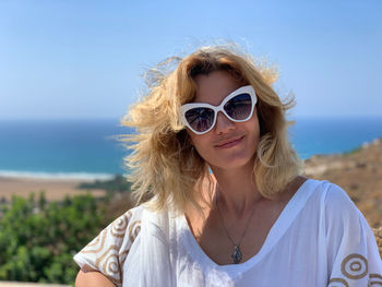 Portrait of woman wearing sunglasses against sea