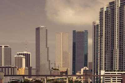 Low angle view of modern buildings against cloudy sky