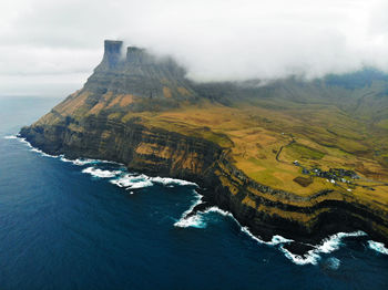 Aerial view of land and sea against sky