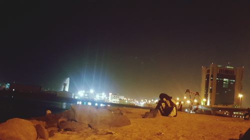 Man standing on illuminated street at night