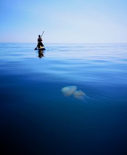 Man surfing in sea against sky