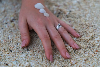 Close-up of hand touching sand