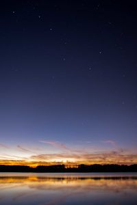 Scenic view of lake against sky at night