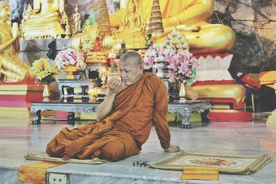 Thoughtful monk sitting in temple