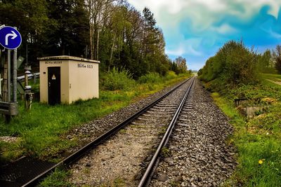 Railroad track amidst trees against sky