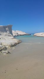 Scenic view of beach against clear blue sky