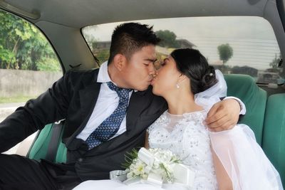 Bridal couple kissing in car