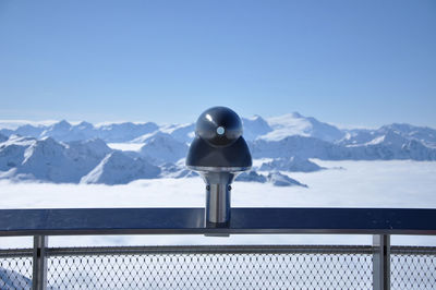 Landscape telescope binocular pointed towards the mountains. snow covered alps in the winter