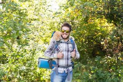 Man standing by plants against trees