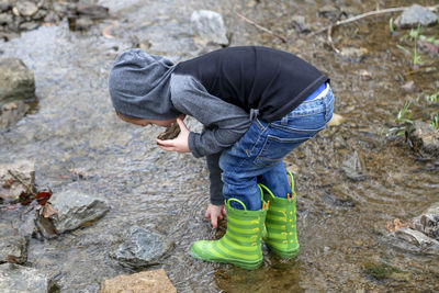 Full length of boy standing on stream