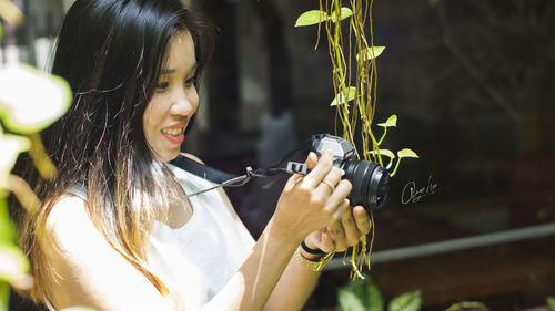 Portrait of young woman holding plant