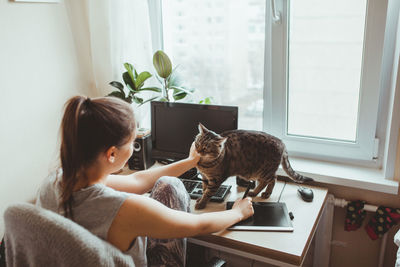 High angle view of woman playing with cat