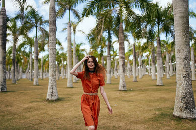 Young woman standing against trees