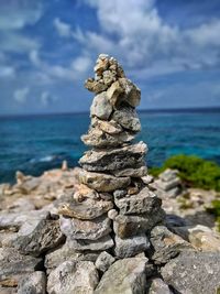 Stack of pebbles on beach against sky