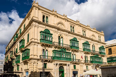 Low angle view of building against cloudy sky