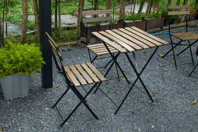 High angle view of empty chairs and table in forest