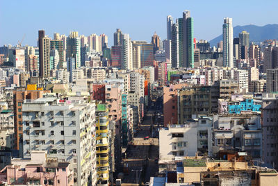 Aerial view of buildings in city against clear sky