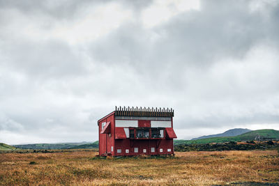 Red house on lonely hillside