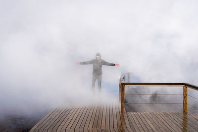 Tourist in steam at gunnuhver hot springs at reykjanes peninsula, iceland