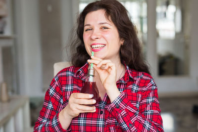 Portrait of smiling woman drinking drink