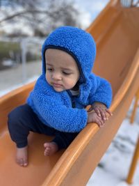 Portrait of cute girl sitting on slide