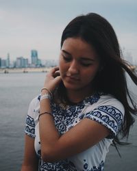 Close-up of beautiful young woman against sky